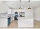Modern kitchen features white cabinetry, granite countertops, stainless appliances, and center island with pendant lighting at 409 S Spargo St, Dallas, NC 28034