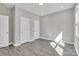 Comfortable bedroom with gray wood-look floors, natural light, and white doors to closets at 427 Queens Ct, Gastonia, NC 28052