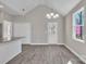 Open area featuring a light fixture, vaulted ceiling, gray wood-look floors, and white trim at 427 Queens Ct, Gastonia, NC 28052