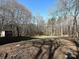 Open backyard space with trees, outbuilding and a circle of red chairs at 4516 Jamee Dr, Gastonia, NC 28056