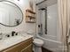 Bathroom with updated vanity, marble countertop, round mirror, and a tub with shower at 4516 Jamee Dr, Gastonia, NC 28056