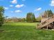 Expansive backyard featuring a lush lawn, mature trees, and the home's deck and patio at 5005 Autumn Blossom Ln, Waxhaw, NC 28173