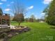 Spacious backyard with a brick fire pit, and lush green lawn, perfect for outdoor enjoyment at 5005 Autumn Blossom Ln, Waxhaw, NC 28173