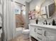 Well-lit bathroom with a modern vanity, stylish mirror and a bathtub with shower and decorative tile surround at 5005 Autumn Blossom Ln, Waxhaw, NC 28173