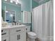 Bright bathroom featuring white vanity and a tiled shower behind a neutral curtain at 5005 Autumn Blossom Ln, Waxhaw, NC 28173