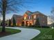 Stately brick home with manicured lawn, mature trees, and elegant curb appeal at 5005 Autumn Blossom Ln, Waxhaw, NC 28173