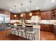 Open concept kitchen with cherry cabinets, granite counters, island with seating, and stainless steel refrigerator at 5005 Autumn Blossom Ln, Waxhaw, NC 28173