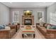 Bright living room featuring a stone fireplace, large windows, and comfortable seating at 5005 Autumn Blossom Ln, Waxhaw, NC 28173