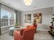 Comfortable living room with two orange chairs, a window with a view, and neutral decor at 5005 Autumn Blossom Ln, Waxhaw, NC 28173