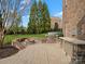 Outdoor kitchen with stone surround, stainless steel grill, and curved brick fire pit at 5005 Autumn Blossom Ln, Waxhaw, NC 28173