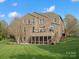 Expansive rear exterior showcasing the home's brick facade, deck, screened porch, and well-maintained backyard at 5005 Autumn Blossom Ln, Waxhaw, NC 28173
