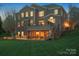 Exterior view of a brick home with a large deck and screened porch overlooking the manicured lawn at 5005 Autumn Blossom Ln, Waxhaw, NC 28173