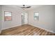 Bedroom with wood floor, two windows, ceiling fan, and access to an updated bathroom at 5310 Myrica Ln, Charlotte, NC 28213