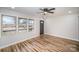 Bright living room featuring hardwood floors, ceiling fan, and large windows offering lots of natural light at 5310 Myrica Ln, Charlotte, NC 28213