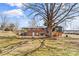 Back exterior featuring a brick facade, covered patio, and a spacious backyard with mature trees at 605 18Th Nw St, Hickory, NC 28601