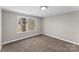Cozy bedroom features neutral walls, plush carpet, and a window view of mature trees at 605 18Th Nw St, Hickory, NC 28601