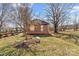 Charming front yard view showcasing a brick home, stone benches, and mature trees at 605 18Th Nw St, Hickory, NC 28601