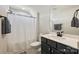 Well-lit bathroom featuring a sleek vanity, white commode, and shower with curtain at 623 Plowshare Way, Clover, SC 29710