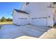 Spacious three car garage, with white doors and a concrete driveway, offering ample parking at 623 Plowshare Way, Clover, SC 29710