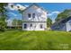 Backyard of a two-story white home with green grass and blue sky at 695 S Elm St, Statesville, NC 28677