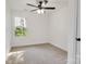 Bright bedroom with soft carpet, ceiling fan, and a sunny window showcasing outdoor greenery at 695 S Elm St, Statesville, NC 28677