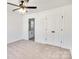 Cozy bedroom featuring plush carpet, ceiling fan, and a view into an attached bathroom at 695 S Elm St, Statesville, NC 28677
