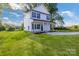 Side view of a two-story home with fresh green grass and bright blue sky at 695 S Elm St, Statesville, NC 28677