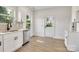 Bright kitchen featuring white cabinets, stainless steel dishwasher, and rear exit door at 695 S Elm St, Statesville, NC 28677