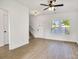 Bright living room with wood-look flooring, ceiling fan, and natural light from double windows at 695 S Elm St, Statesville, NC 28677