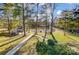 Scenic backyard featuring a lush lawn, mature trees, lake view, and outdoor entertaining spaces at 7201 Cedarfield Rd, Charlotte, NC 28227