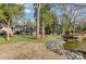 Expansive backyard featuring a lake, multiple buildings, gazebo and lush green space at 7201 Cedarfield Rd, Charlotte, NC 28227