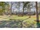 A serene backyard featuring a lake, dock, gazebo, and lush green grass at 7201 Cedarfield Rd, Charlotte, NC 28227