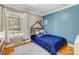 Bright bedroom with blue accent wall, wood floors, and a cute bed for a  at 7201 Cedarfield Rd, Charlotte, NC 28227