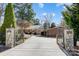 Gated entrance leads to a brick home with a large driveway and a carport at 7201 Cedarfield Rd, Charlotte, NC 28227