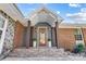 Welcoming front entrance with stone pillars, a wreath on the front door, and manicured plants at 7201 Cedarfield Rd, Charlotte, NC 28227