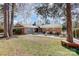 Charming brick home features a stone accent wall, a landscaped front yard, and mature trees at 7201 Cedarfield Rd, Charlotte, NC 28227
