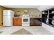 Functional kitchen space featuring white appliances, wooden cabinets, and tiled flooring for easy maintenance at 7201 Cedarfield Rd, Charlotte, NC 28227