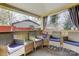 Relaxing covered patio space with comfortable wicker chairs and a small table, perfect for enjoying the outdoors at 7201 Cedarfield Rd, Charlotte, NC 28227
