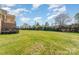 Large backyard with lush green grass and mature trees at 8137 Caliterra Dr, Charlotte, NC 28227