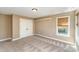 Bedroom featuring tan walls, carpeted floor, closet, and window with blinds at 8137 Caliterra Dr, Charlotte, NC 28227
