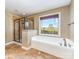 Luxurious main bathroom features a soaking tub, tiled walk-in shower, and a large window at 8137 Caliterra Dr, Charlotte, NC 28227
