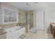 Well-lit primary bathroom featuring a glass shower and separate tub near a bright window at 8606 Chatsworth Ln, Waxhaw, NC 28173