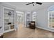 Sunlit office space with built-in bookshelves, french doors, and a comfortable chair at 8606 Chatsworth Ln, Waxhaw, NC 28173