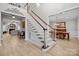 Elegant staircase featuring wood and white trim, and views to living and dining areas at 8606 Chatsworth Ln, Waxhaw, NC 28173