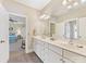 Bathroom with dual sinks, white cabinets, and a view into an adjacent room at 8915 Heydon Hall Cir, Charlotte, NC 28210