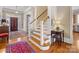 Grand foyer with hardwood floors, staircase, console table, and a view of the front door and living spaces at 8915 Heydon Hall Cir, Charlotte, NC 28210