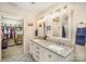 Bathroom featuring double sinks with granite countertops, decorative mirrors, a separate toilet, and a spacious walk-in closet at 1016 E 10Th St, Kannapolis, NC 28083