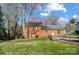 Backyard with a brick house, basketball hoop, and wood fence at 1301 Old Farm Rd, Charlotte, NC 28226