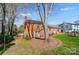 Exterior view of a brick home showing the backyard with a mature tree and adjacent white house at 1301 Old Farm Rd, Charlotte, NC 28226