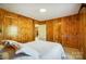 Comfortable bedroom with wood paneled walls and a view into another room at 1301 Old Farm Rd, Charlotte, NC 28226